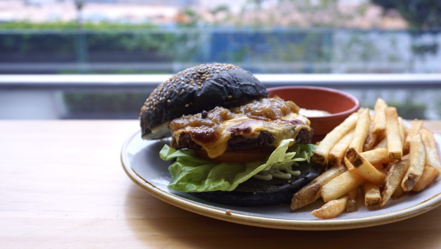Wagyu beef burger with charcoal bun and fries at 209 Cafe
